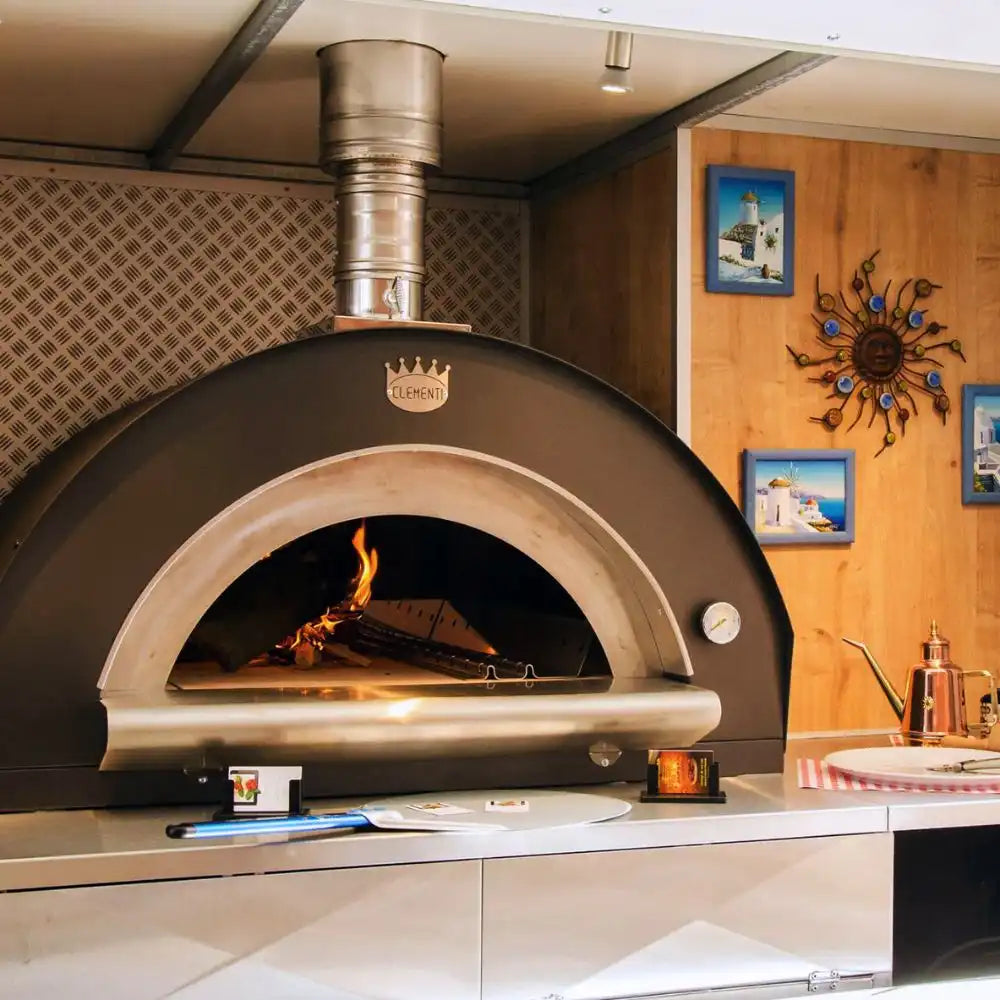 Wood-fired oven in a kitchen setting with decorative elements on the wall.