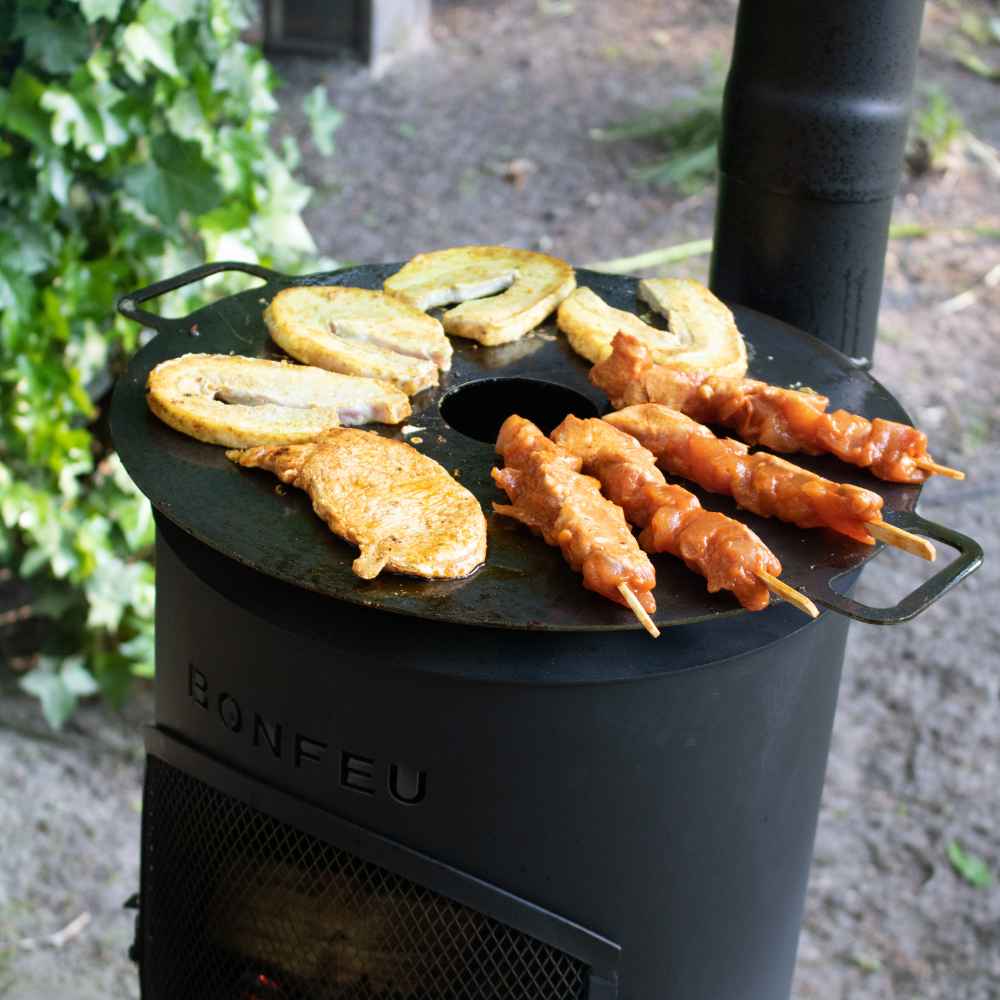 Outdoor cooking setup with a portable stove and grill, featuring skewered food.
