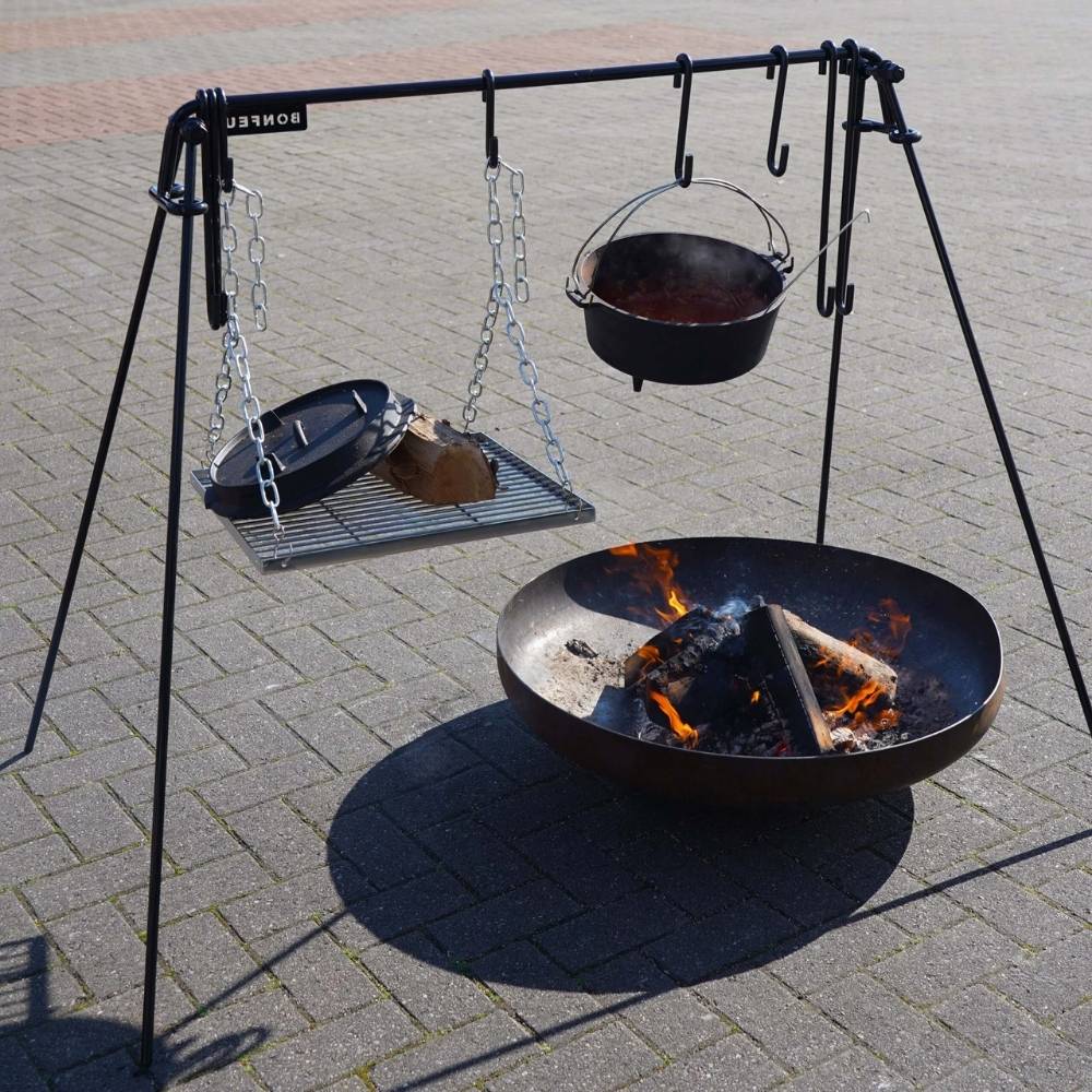 Outdoor fire pit with cooking equipment on a metal stand