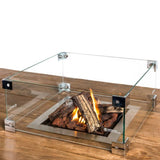 Square Glass set for Fire Pit Table with burning logs on a wooden surface