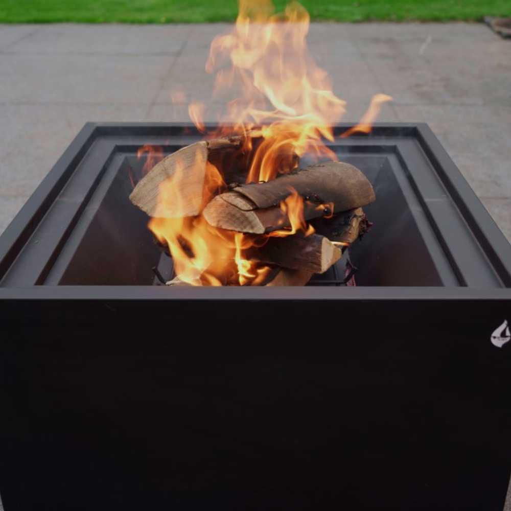 Fire pit with flames and wooden logs on a patio