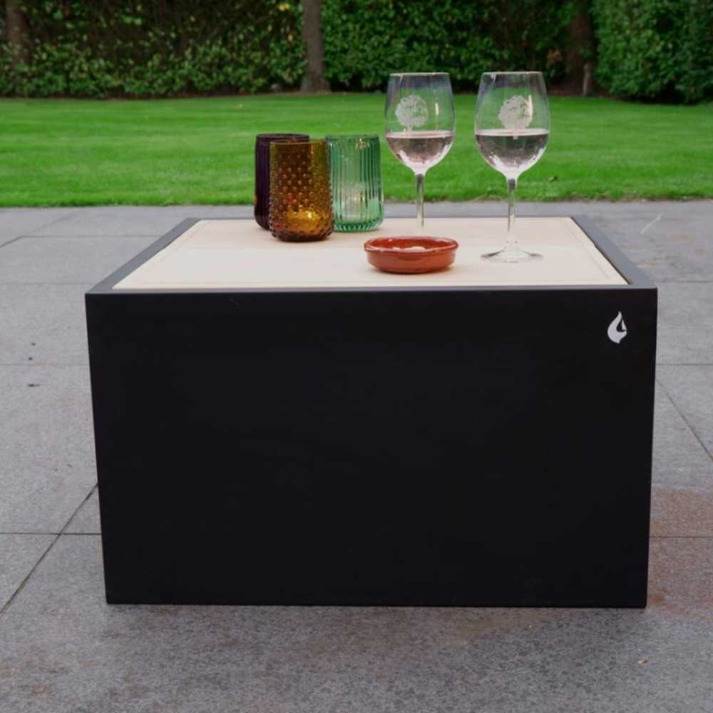 Black outdoor coffee table with glasses and a bowl on a patio