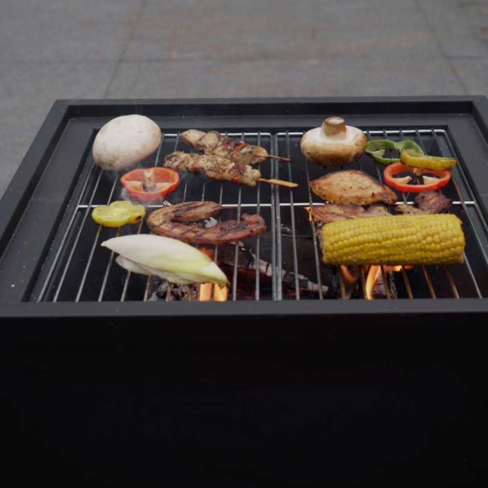Grill with various food items being cooked on a paved surface