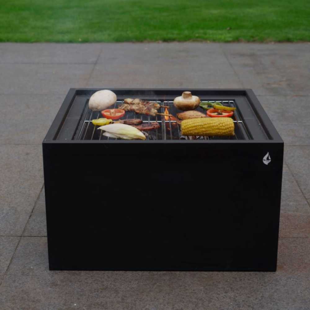Black rectangular grill with food on a paved surface