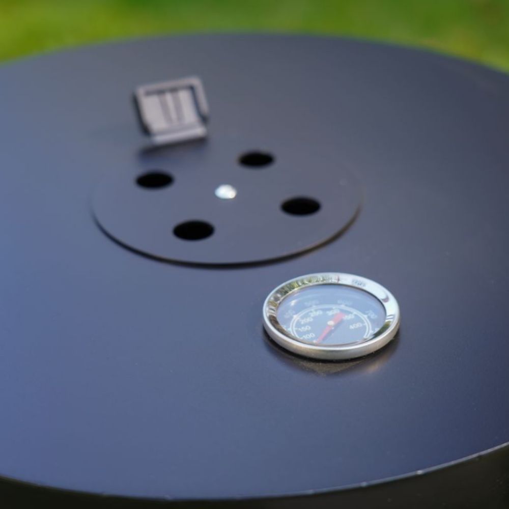 Barbecue grill with thermometer and digital display on a grassy background