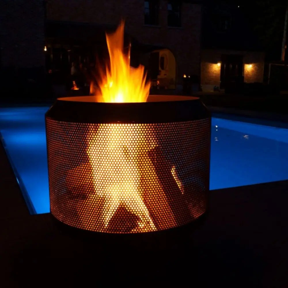 Fire pit with flames glowing brightly in a dark outdoor setting.