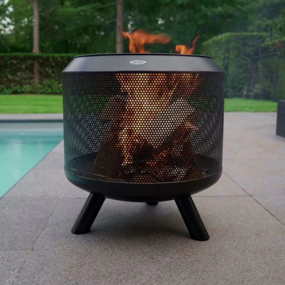 Black mesh fire pit with flames burning outdoors near a pool