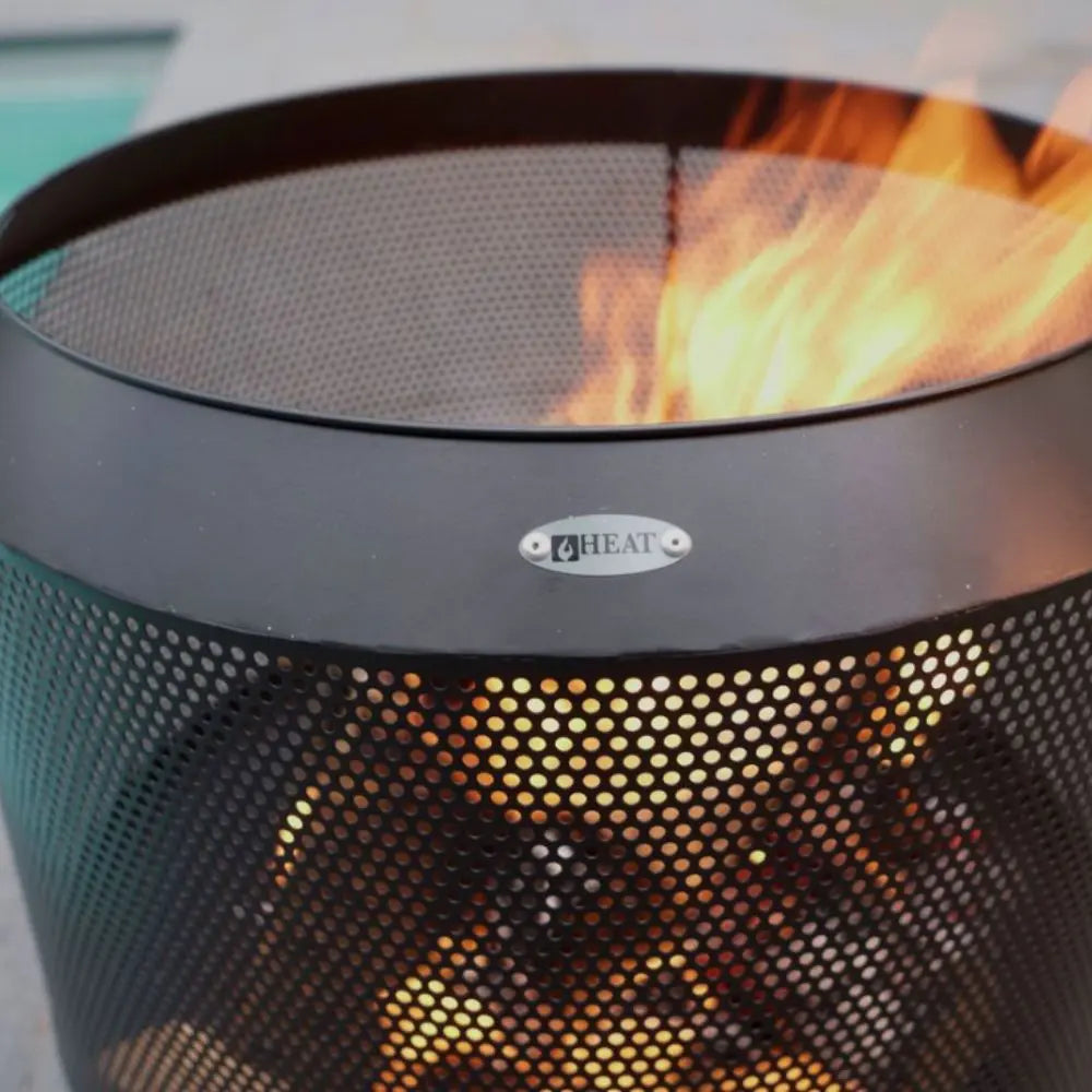 Mesh fire basket with flames inside, featuring a brand logo on a blurred background.