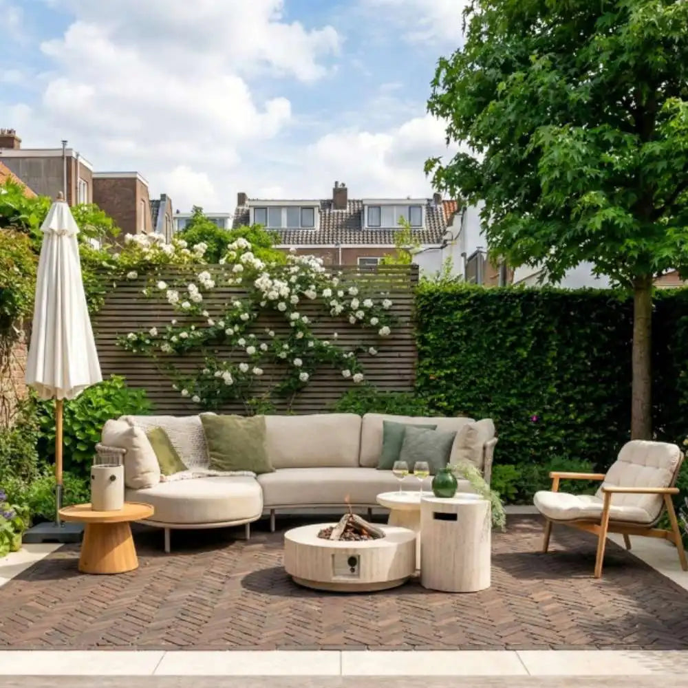 Outdoor patio with a sectional sofa, chairs, and a fire pit table in a garden setting.