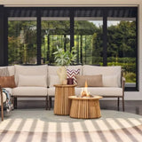 Outdoor patio setting with a beige sofa, fire pit table, and decorative items.