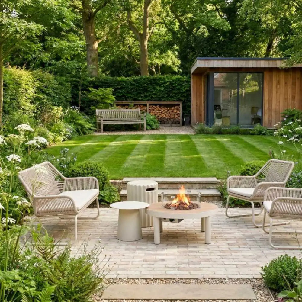 Outdoor patio with fire pit, chairs, and garden setting