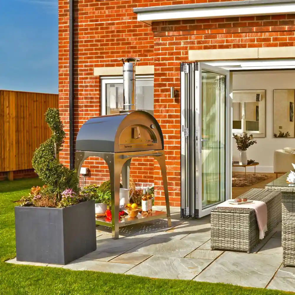 Outdoor patio area with a brick wall, pizza oven, and garden furniture.
