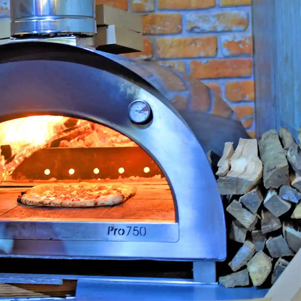 Wood-fired pizza oven with a pizza inside, set against a brick wall.
