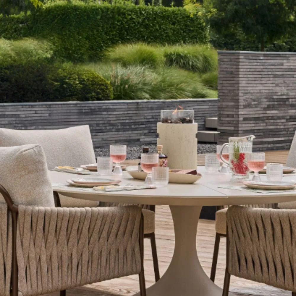 Outdoor dining setup with table, chairs, Table Top Burner, and drinks on a patio.