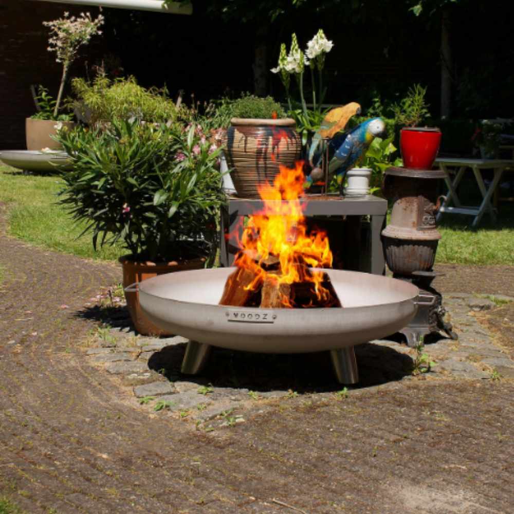 Outdoor fire pit with flames in a garden setting