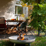 Outdoor fire pit with flames in a garden setting