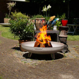 Outdoor fire pit with flames in a garden setting