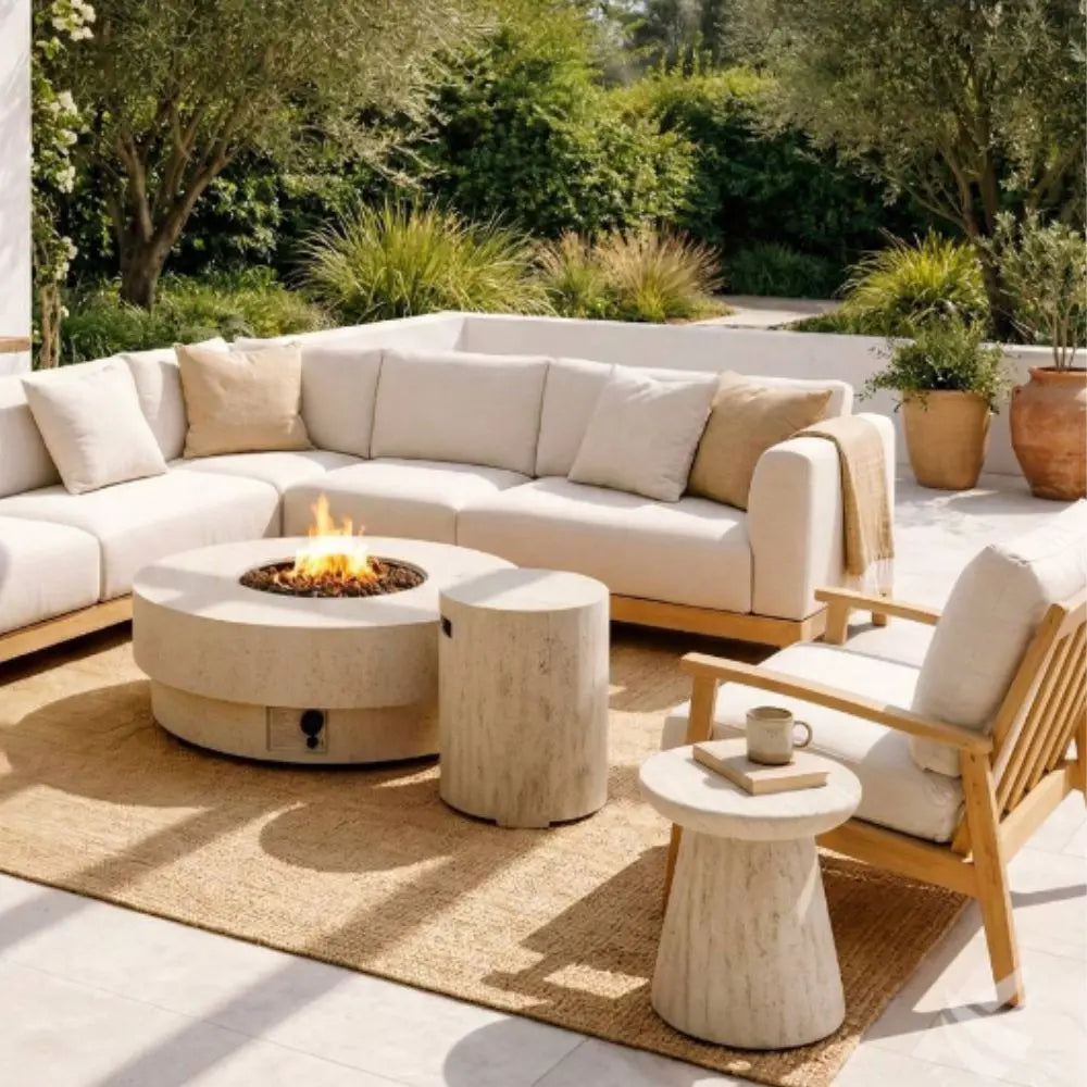 Outdoor patio with beige sectional sofa, fire pit table, side table and wooden chairs in a garden setting.