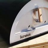 Close-up of a pizza oven with 'Igneus' branding on a wooden surface.